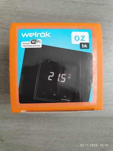 На изображении коробка от умного терморегулятора Welrok с отображением времени 21:15 и надписью "WiFi". (Captioned by AI)