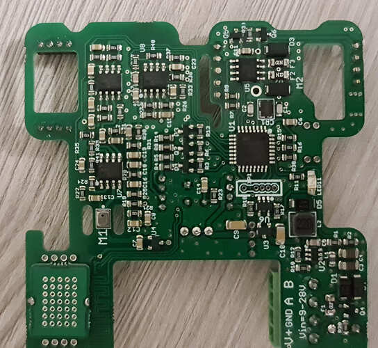На изображении показана печатная плата с различными электронными компонентами, включая микросхемы и резисторы. (Captioned by AI)