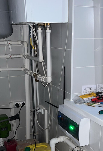 На изображении показана система трубопроводов, подключенная к водонагревателю, с различными инструментами и аксессуарами на поверхности рядом. (Captioned by AI)