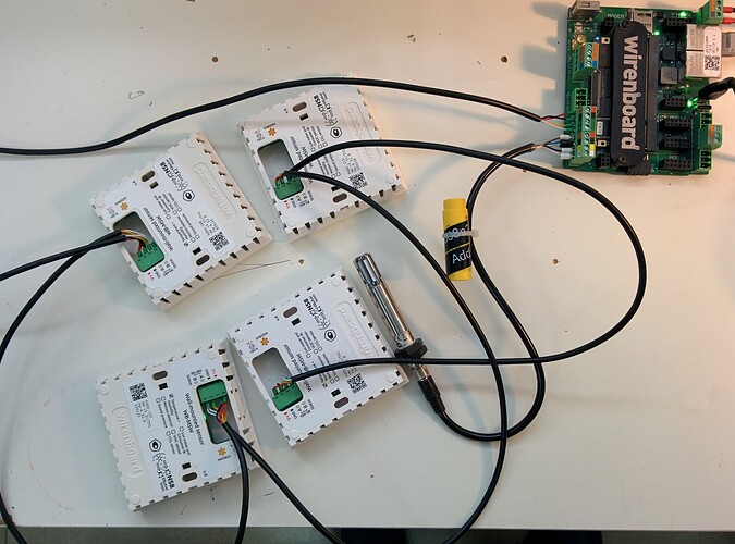 На изображении представлены четыре устройства, соединенные проводами с платой Wirenboard, а также инструмент с желтой крышкой и надписью "Add". (Captioned by AI)