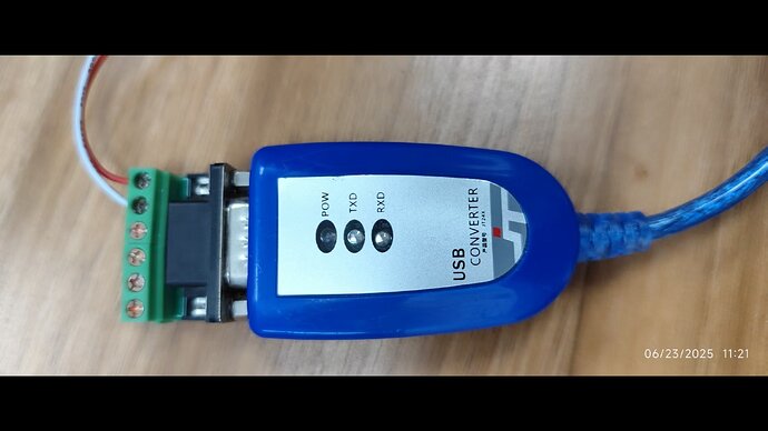 На изображении представлен USB-переходник синего цвета с индикаторами состояния POWER, TXD и RXD, подключённый к разъему. (Captioned by AI)