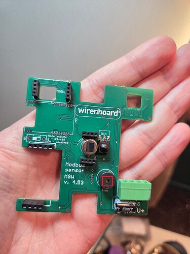 На изображении показана печатная плата Modbus сенсора версии 4.63, удерживаемая в руке. (Captioned by AI)