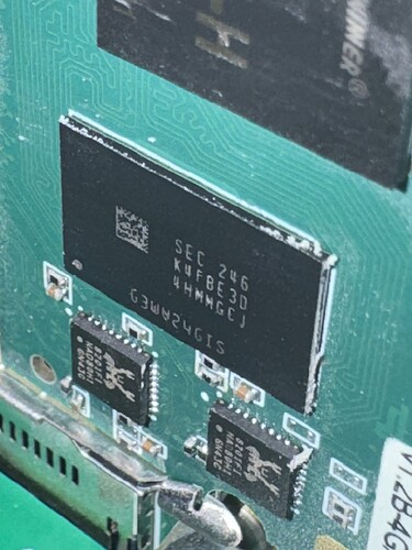 На изображении показана печатная плата с микросхемой памяти и несколькими маленькими чипами на ней. (Captioned by AI)