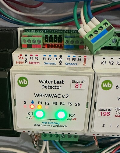 На изображении представлен детектор протечек воды WB-MWAC v.2 с индикаторами состояния и разъемами для подключения. (Captioned by AI)