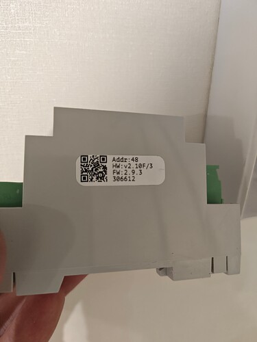 На изображении видно устройство с серым корпусом и наклейкой, содержащей QR-код и информацию о модели и версии. (Captioned by AI)