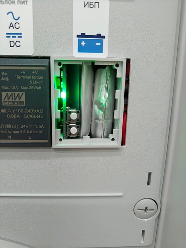 На изображении показан блок питания с зеленым индикатором и панелью управления, открытый для доступа к внутренним компонентам. (Captioned by AI)