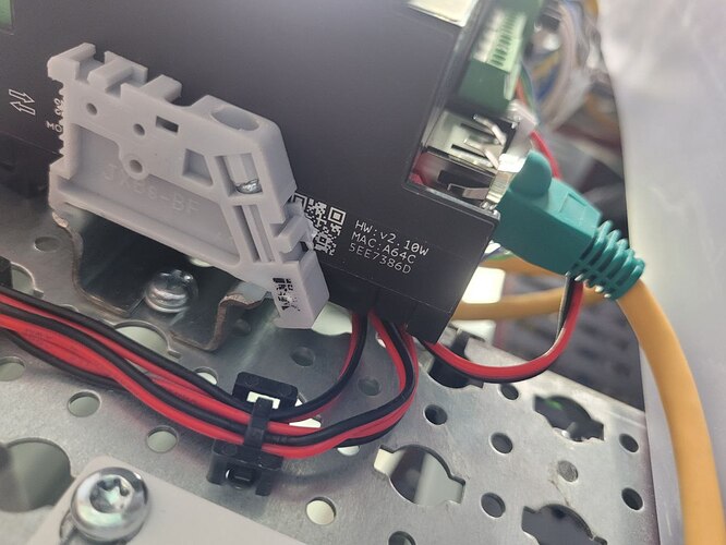 На изображении показано устройство с подключенными проводами, включая RJ-45, установленное на металлической панели. (Captioned by AI)