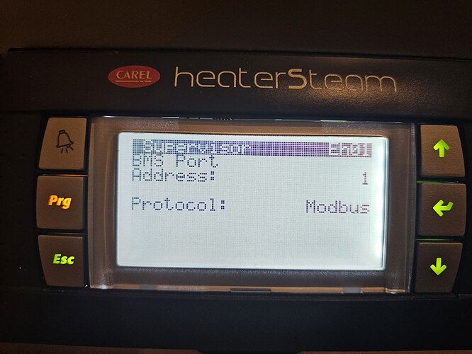 На экране устройства Carel heaterSteam отображается информация о настройках, включая параметры связи, такие как порт, адрес и протокол Modbus. (Captioned by AI)