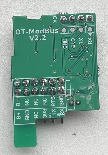 На изображении показана печатная плата OT-ModBus версии 2.2 с несколькими выводами и подписанными контактами. (Captioned by AI)