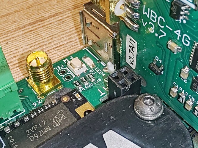 На изображении представлена печатная плата с различными компонентами, включая разъемы и металлический штекер. (Captioned by AI)