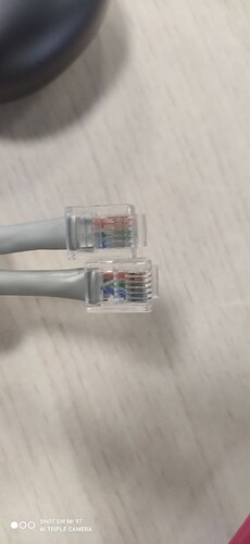На изображении представлены два разъема RJ45 с видимыми цветными проводами внутри. (Captioned by AI)
