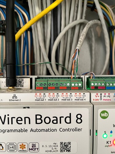 На изображении представлена плата "Wiren Board 8" с подключенными проводами и модулями для программируемого автоматизированного контроля. (Captioned by AI)