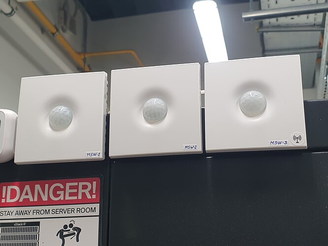 На изображении три устройства MSW1, MSW2 и MSW3, расположенные на стене рядом с предупреждающей табличкой "DANGER! STAY AWAY FROM SERVER ROOM". (Captioned by AI)