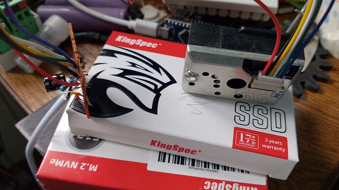 На изображении показан SSD-накопитель KingSpec, подключенный к различным провода и компонентам, вероятно, в процессе сборки или тестирования. (Captioned by AI)