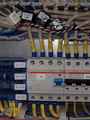 На изображении показано электрическое распределительное устройство с несколькими автоматическими выключателями и подключенными проводами. (Captioned by AI)