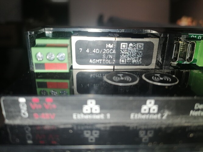 На изображении представлен компонент с меткой, отображающей информацию о модели и серийном номере, расположенный рядом с разъемами Ethernet и питанием. (Captioned by AI)