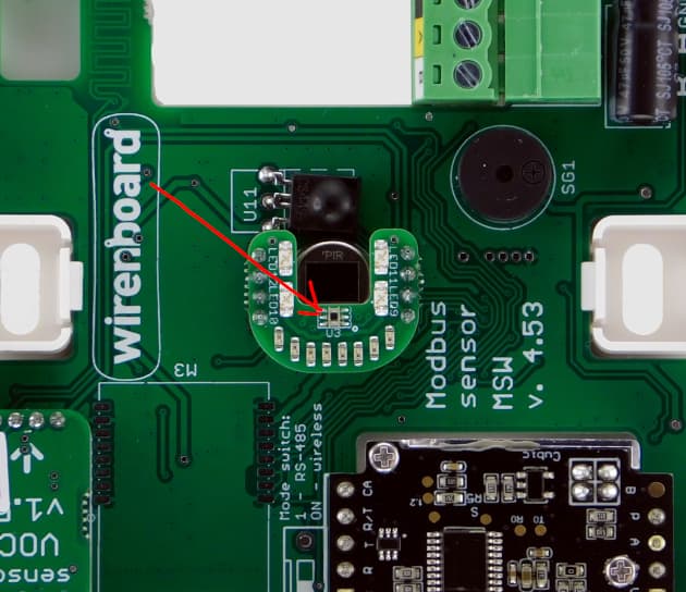 На изображении представлена печатная плата устройства под названием "Wirenboard" с выделенным компонентом, вероятно, датчиком. (Captioned by AI)